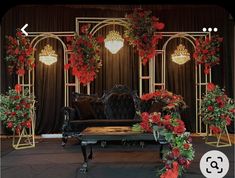 a couch and table with flowers on it in front of a stage set for an event