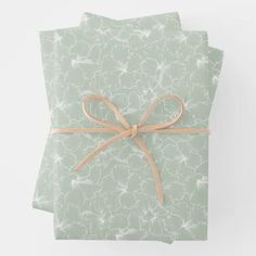 two green napkins tied together with a brown ribbon