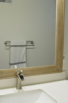 a bathroom sink with a towel hanging on the rack in front of it and a mirror above it