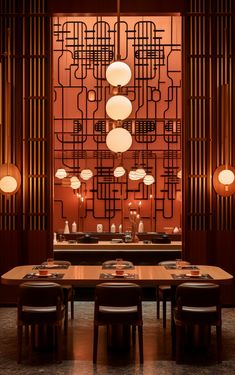 a dining room table with chairs and lights on the wall in front of an intricate screen