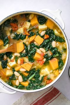 a pot full of soup with spinach and chickpeas in it on a table