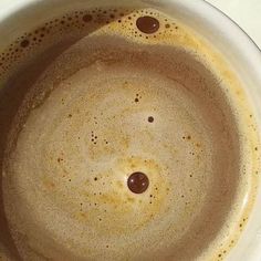 a white bowl filled with brown liquid on top of a table