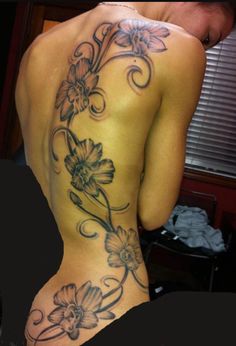 the back of a woman's body with flowers on her lower and upper half