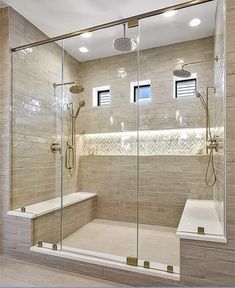 a walk in shower sitting next to a white bath tub under two recessed lights