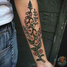 a woman's arm with flowers and leaves on the left side of her arm