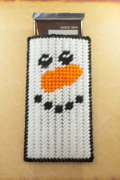 a cell phone case made to look like a snowman with an orange nose and black eyes