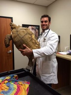 a man in a lab coat holding a turtle shell