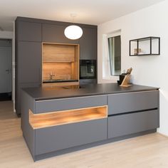 a kitchen with grey cabinets and wooden floors