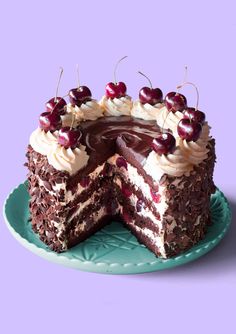 a chocolate cake with white frosting and cherries