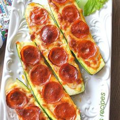 zucchini stuffed with pepperoni and cheese on a white platter next to parsley