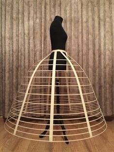 a mannequin standing in front of a dress made out of metal wire and wood