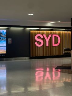 an airport lobby with a sign that says syd on the wall and another sign behind it