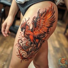 a woman's thigh with an orange and black bird on it