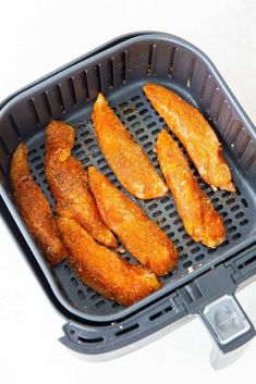 chicken wings are being cooked in an air fryer