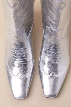 Amp up your cool-girl vibes with the Steve Madden Dollie Silver Leather Knee High Western Boots! Metallic crinkly silver genuine leather shapes a squared, pointed-toe upper that rises to a 13"" knee-high shaft with a 14.5"" circumference and a curved topline with pull-tabs. Western-inspired seaming and embroidery accent throughout the slip-on design, all atop a classic, stacked block heel. 1. 75" stacked block heel. Lightly cushioned insole. Rubber sole has nonskid markings. Genuine leather upper. Balance man made materials. Imported. Lulus | Dollie Silver Leather Knee High Western High Heel Boots | Size 7. Knee High Western Boots, Heel Boots, High Heel Boots, Western Boots, High Heel, Knee High, Steve Madden, Block Heels, Cool Girl