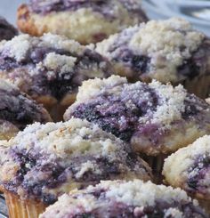 blueberry muffins with powdered sugar on top in a glass dish, ready to be eaten