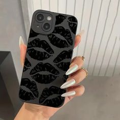 a woman's hand holding an iphone case with black lips on it