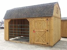 a large wooden barn with a horse stable attached to it's roof and doors