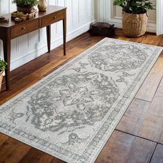 a large rug is on the floor in a room with wooden floors and white walls