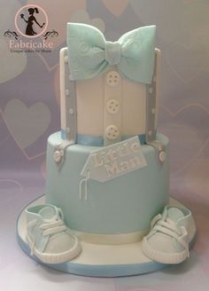 a blue and white cake decorated with baby shoes