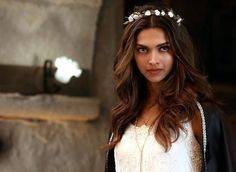 a woman with long hair wearing a white dress