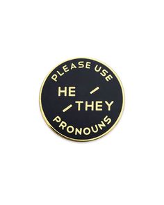 a black and gold pin with the words please use she's pronouns