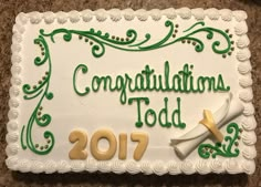 a white cake with green writing on it that says congratulations to the year 2077