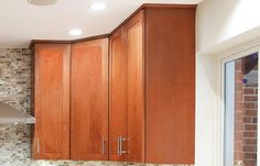 a kitchen with wooden cabinets and marble counter tops