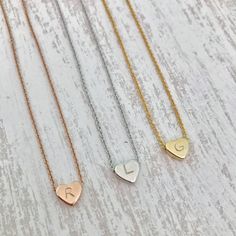 "Dainty Hand Stamped Initial Heart Necklace This hand stamped heart charm necklace makes the perfect gift! Stamp in your kids, grandkids, nieces, nephews, god-child's (or any child!) initials for a one-of-a-kind, keepsake accessory. Be sure to include what initial you would like stamped in the heart charm in the comments section when ordering!! Each heart charm finish will match the finish of the necklace chosen unless otherwise requested Listing for one necklace in Rose Gold, Silver or Gold fin Personalized Heart Shaped Rose Gold Necklace, Open Heart Necklace With Heart Print For Gifts, Dainty Heart Charm Necklace For Birthday, Heart Print Open Heart Necklace For Gift, White Heart Charm Necklace For Birthday, Dainty Hand Stamped Heart Necklaces, Cute Heart Pendant Necklace For Birthday, White Heart Necklace For Birthday, Mother's Day Gift Heart Print Necklace