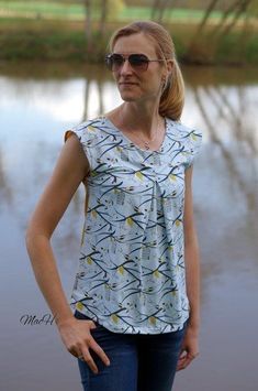 a woman standing in front of a body of water with her hands on her hips