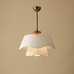 a white lamp hanging from a ceiling in a room with beige walls and flooring