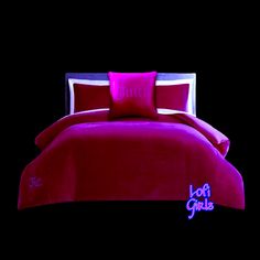 a bed with red sheets and pillows in the dark