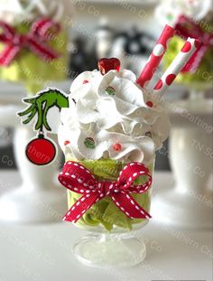 a cup filled with whipped cream and candy canes on top of a table next to other items