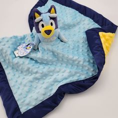 a stuffed animal laying on top of a blue blanket