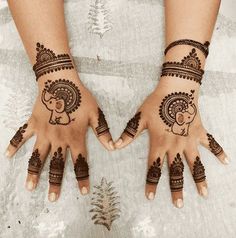 two hands with henna designs on them, one is showing an elephant and the other has