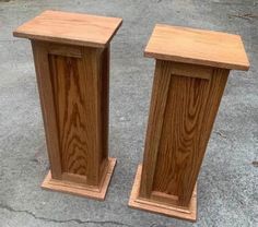 two wooden pedestals sitting on top of cement