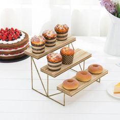 three tiered trays filled with pastries and fruit on top of a table