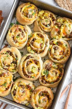 a pan filled with breakfast rolls on top of a table