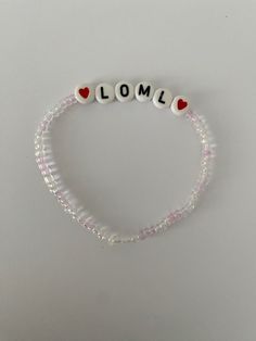 a beaded bracelet with the word lomo written in white beads and red hearts