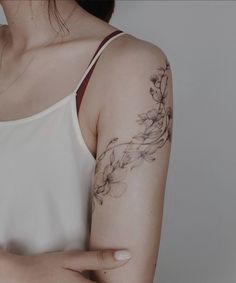 a woman with a flower tattoo on her left arm and right arm behind her back