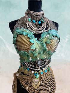 a mannequin is adorned with jewelry and beads on it's neckline