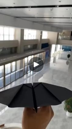 someone is holding an umbrella in the middle of a room with many windows and doors