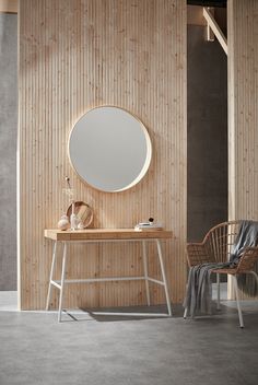 a wooden table with a mirror on it and a chair next to it in front of a wall