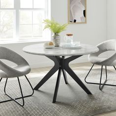 a white table with two chairs and a potted plant in the corner on top