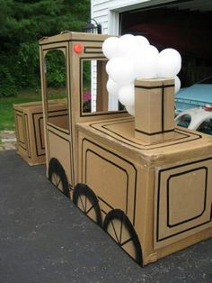 a cardboard train with balloons attached to it