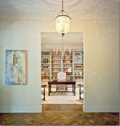 an open door leading to a dining room with a table and bookshelf in the background