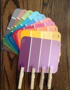 a bunch of different color swatches sitting on top of a wooden table next to each other