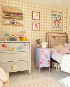 a child's bedroom decorated in pastel colors and gingham checkered wallpaper