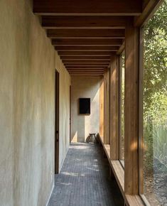 an empty hallway with wood and brick flooring next to tall windows on both sides