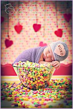 a baby is sleeping in a bowl full of candies with the words boa notte above it